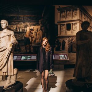 A woman standing in front of statues in a museum